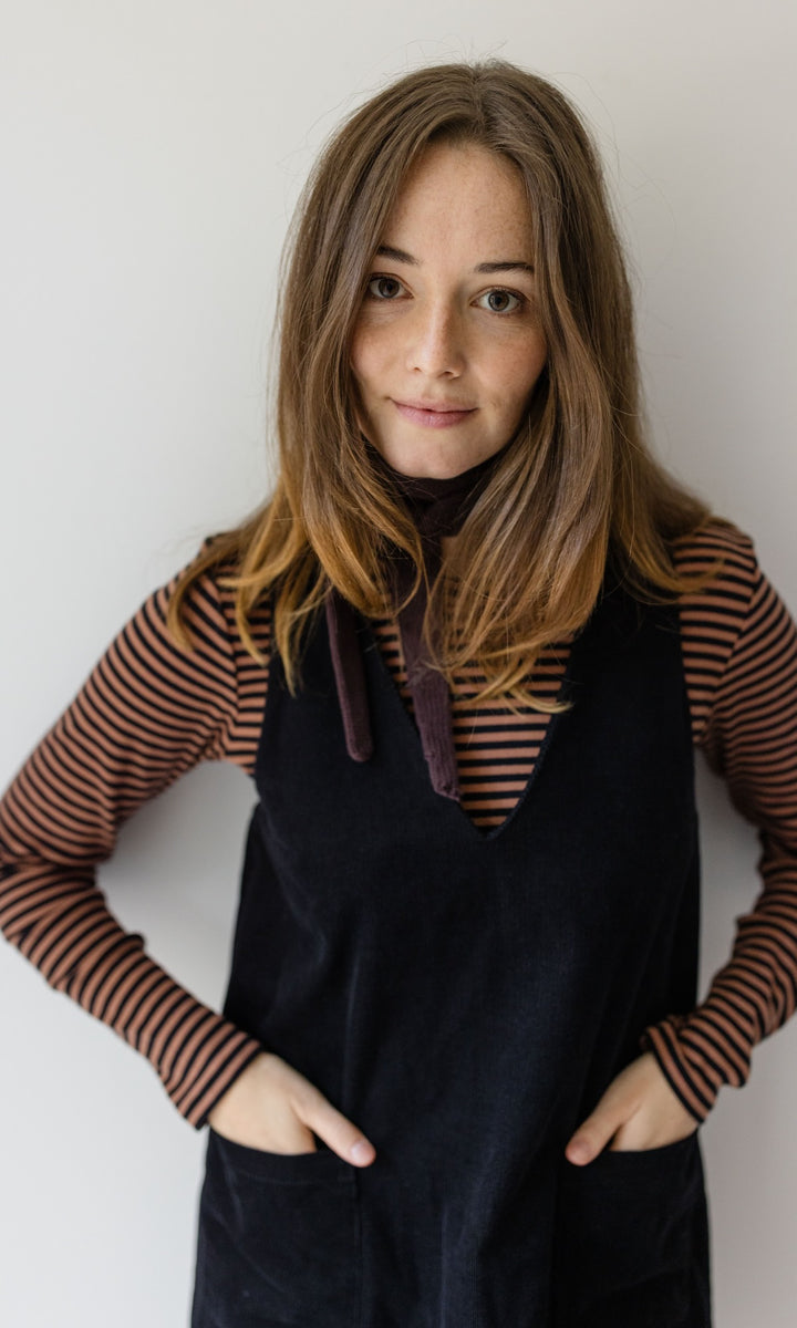 Langarm Stillshirt Zoe in braun gestreift kombiniert mit schwarzem Kleid und braunem Halstuch vor grauer Wand von vorne Blick gerade