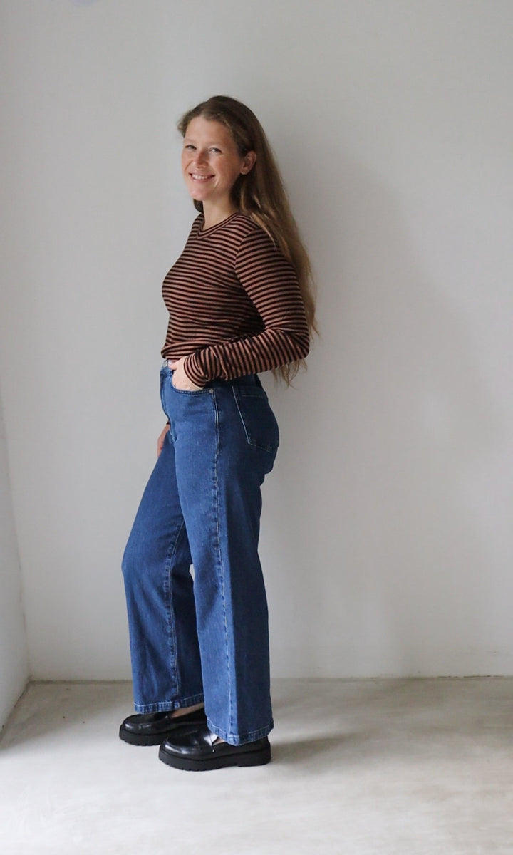 Langarm Stillshirt Zoe in braun gestreift kombiniert mit blauer Jeans vor grauer Wand seitlich Blick seitlich lachend