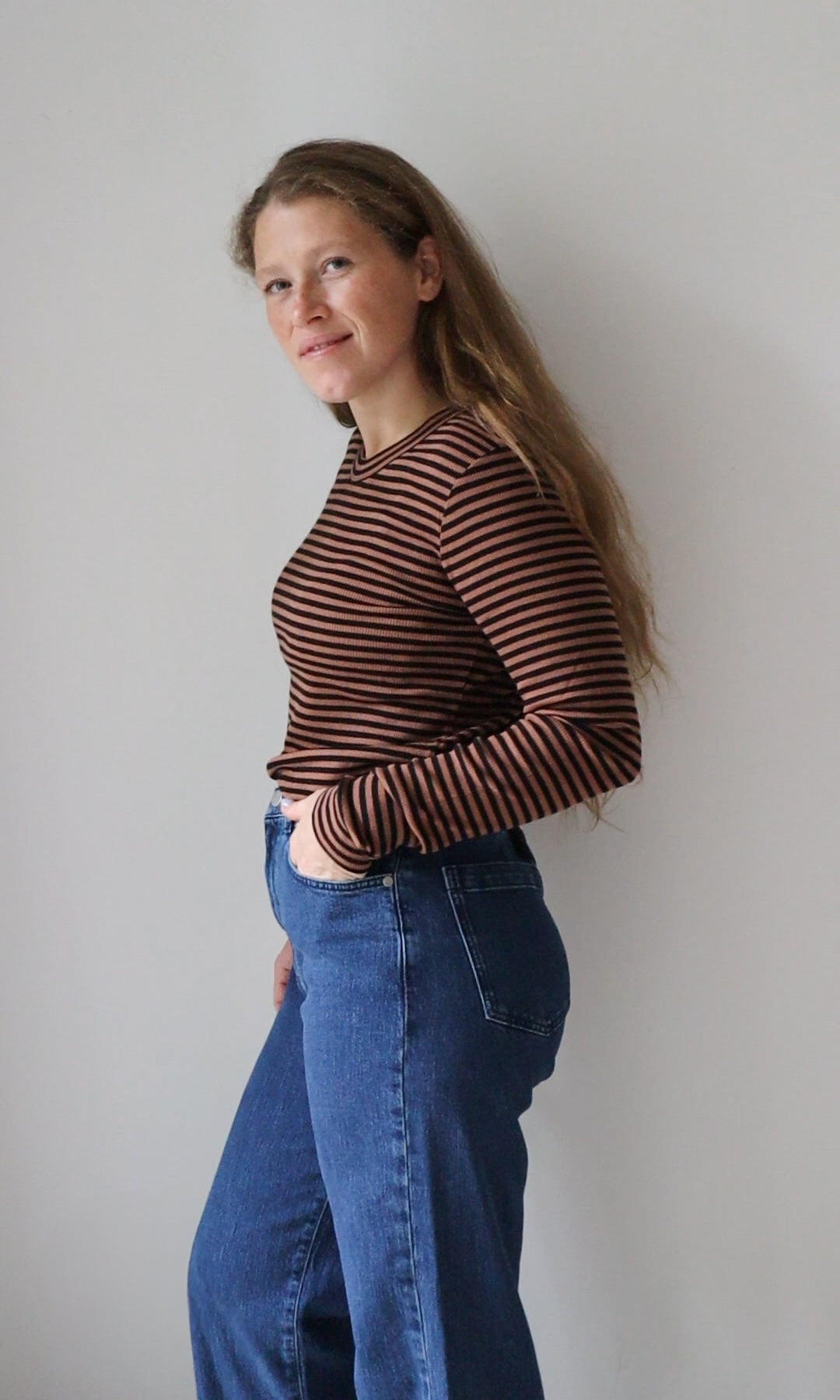 Langarm Stillshirt Zoe in braun gestreift kombiniert mit blauer Jeans vor grauer Wand seitlich Blick seitlich