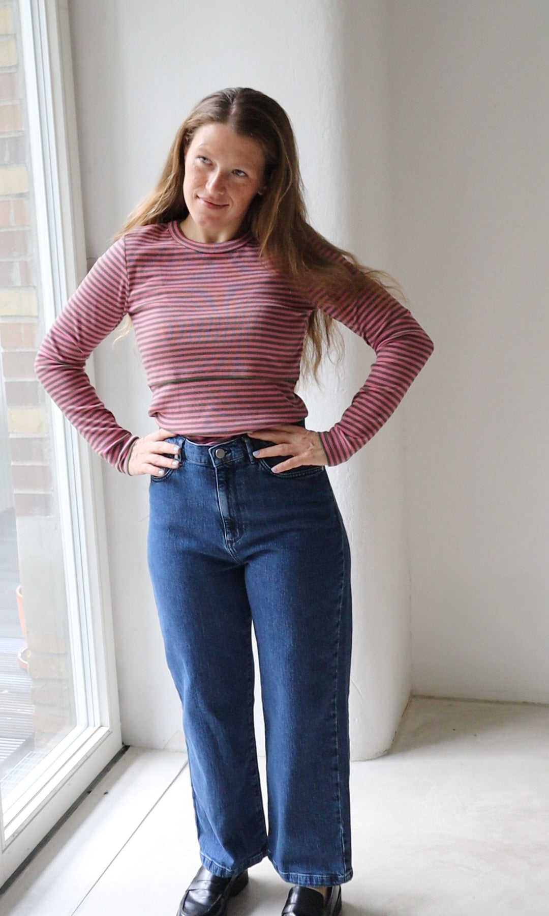 Langarm Stillshirt Zoe in rosa gestreift kombiniert mit blauer Jeans vor grauer Wand von vorne Blick seitlich