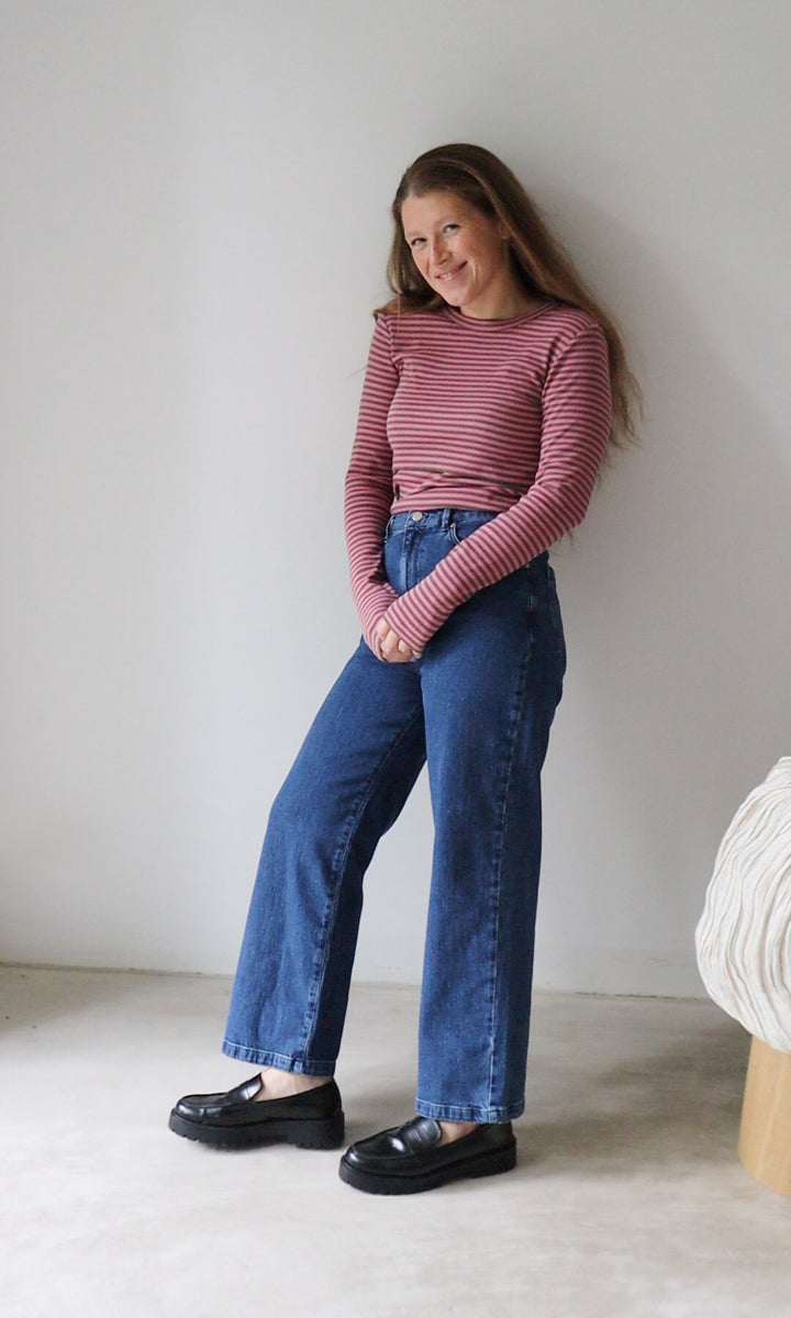 Langarm Stillshirt Zoe in rosa gestreift kombiniert mit blauer Jeans vor grauer Wand von vorne Blick gerade lächelnd