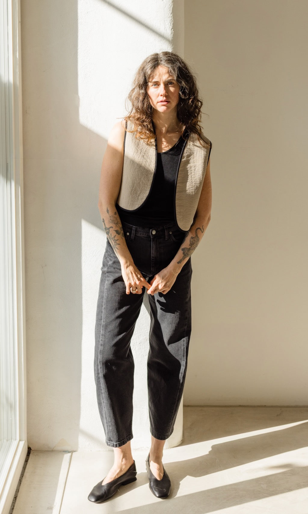 Leichte wendbare Steppweste in schwarz und creme kombiniert mit schwarzer Barrel-Jeans und schwarzen Loafers - Creme-farbige Seite außen