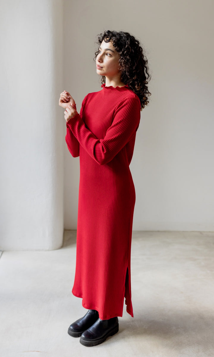 Rotes Strickkleid Jil langarm mit schwarzen Stiefeln seitlich stehend Blick gerade