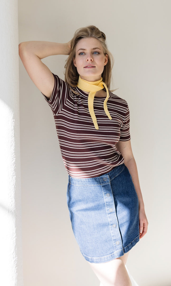 Jeans Minirock in denim blau mit Knöpfen aus Bio-Baumwolle kombiniert mit braun gestreiftem Shirt und kleinem gelben Strickschal