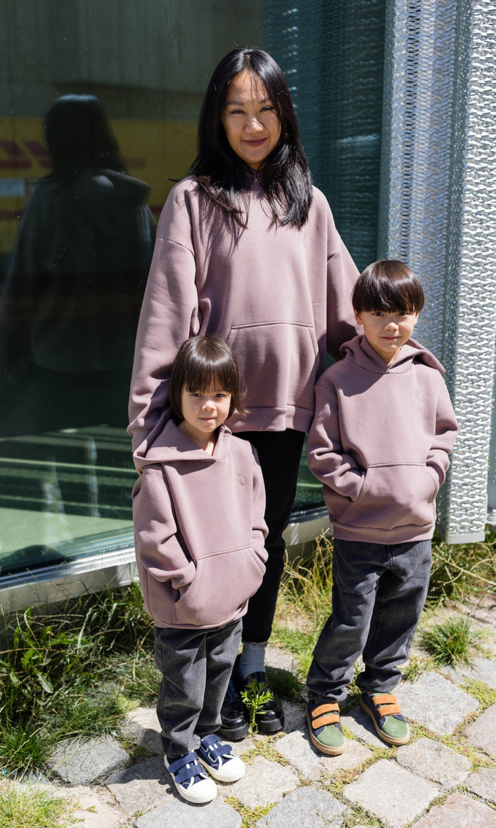 Still Hoodie in aubergine rot stehend mit Frau und zwei Kindern alle mit Still-Hoodie Blick nach vorne