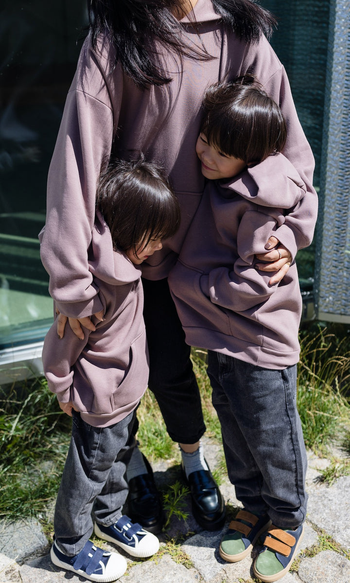 Still Hoodie in aubergine rot stehend mit Frau und zwei Kindern alle mit Still-Hoodie zusammen stehend