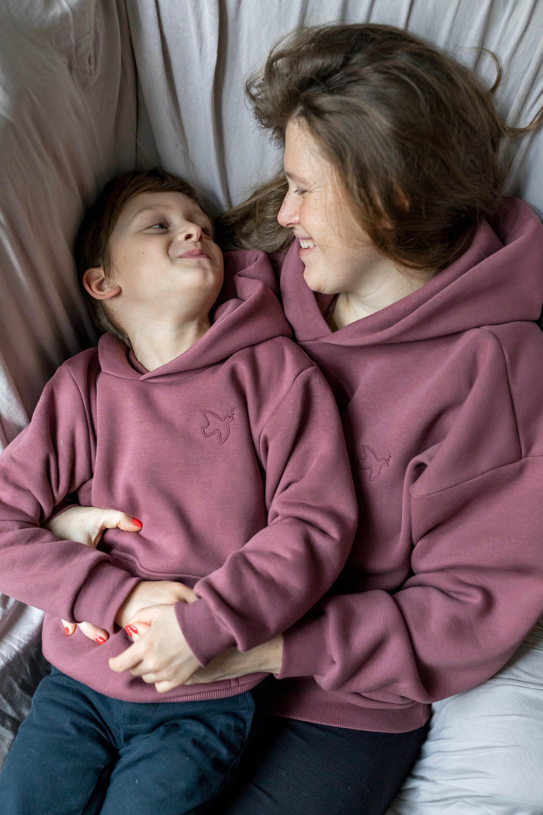 Still-Hoodie in feige rosa zusammen mit Kind in gleichem Hoodie lächelnd