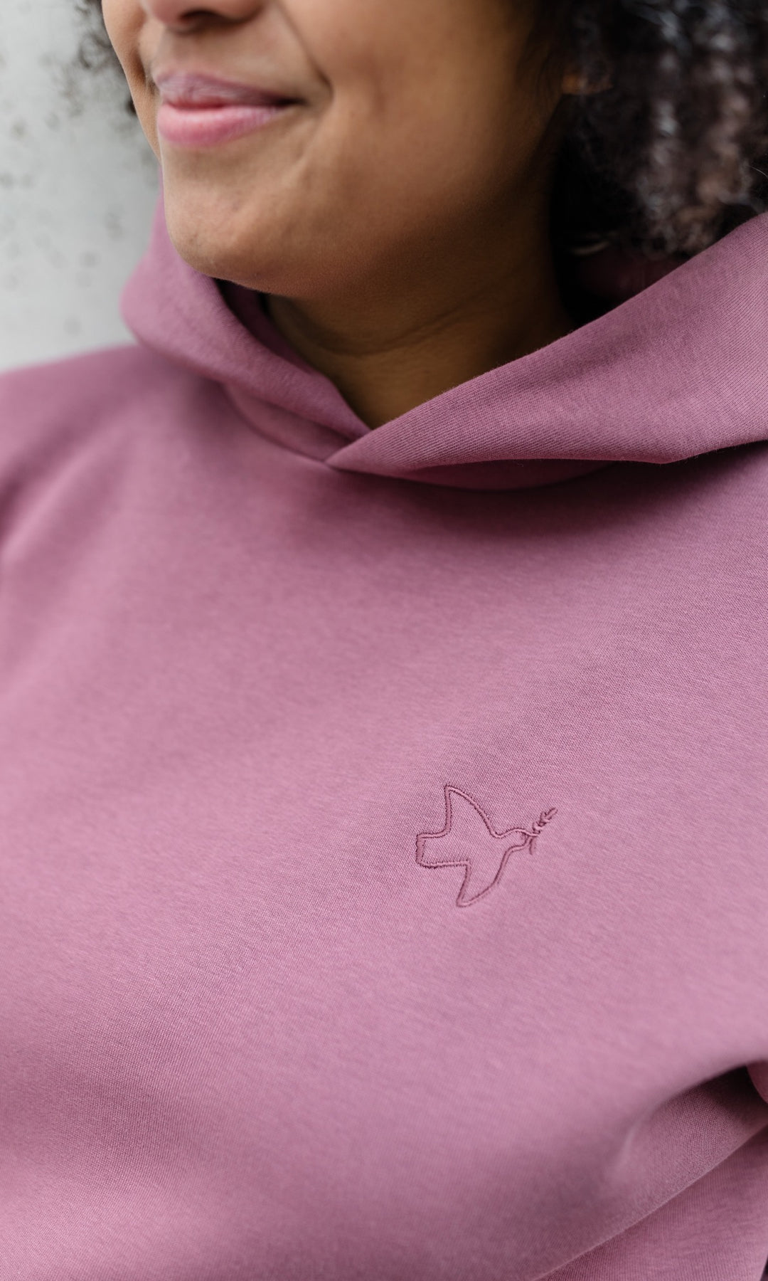 Still-Hoodie in feige rosa Detailaufnahme Logo abricot coco lächelnd