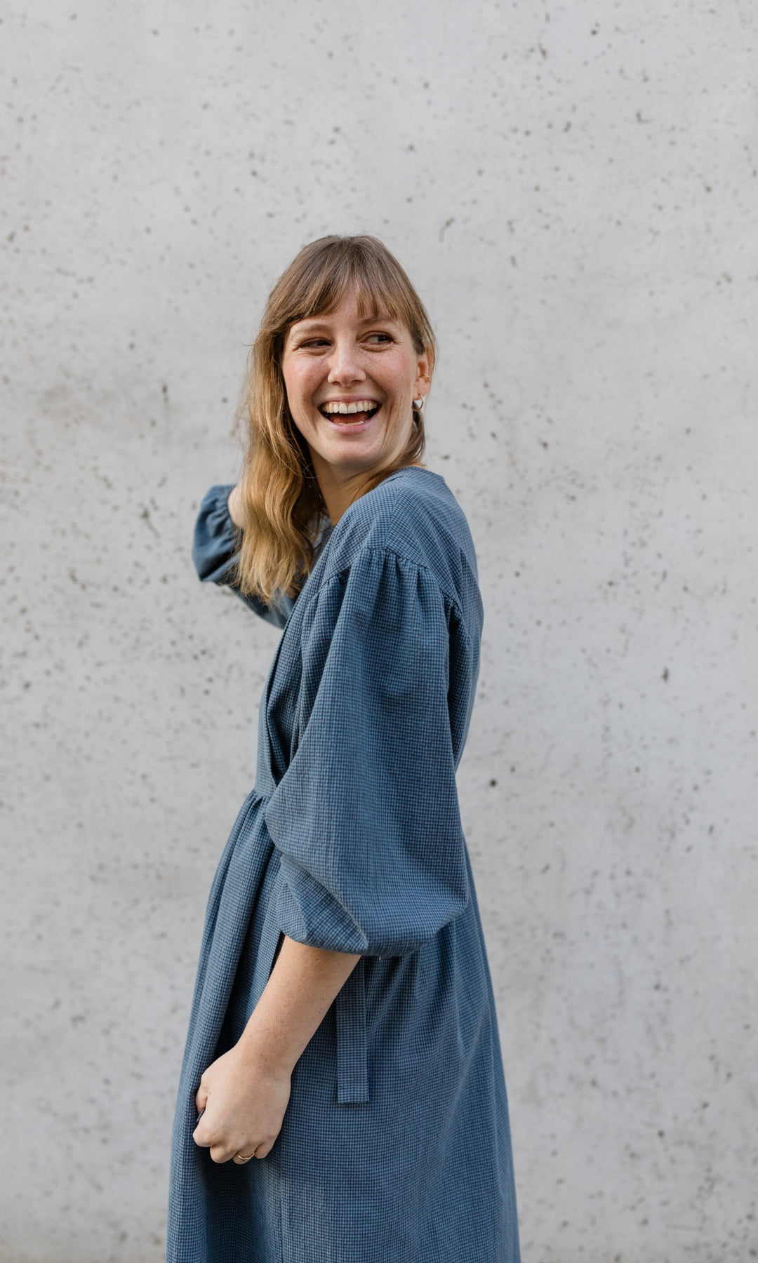 Langes Stillkleid Anouk in karo blau seitlich vor Wand