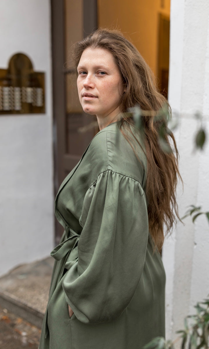 Stillkleid Shania in olive grün Blick seitlich Hände in Taschen