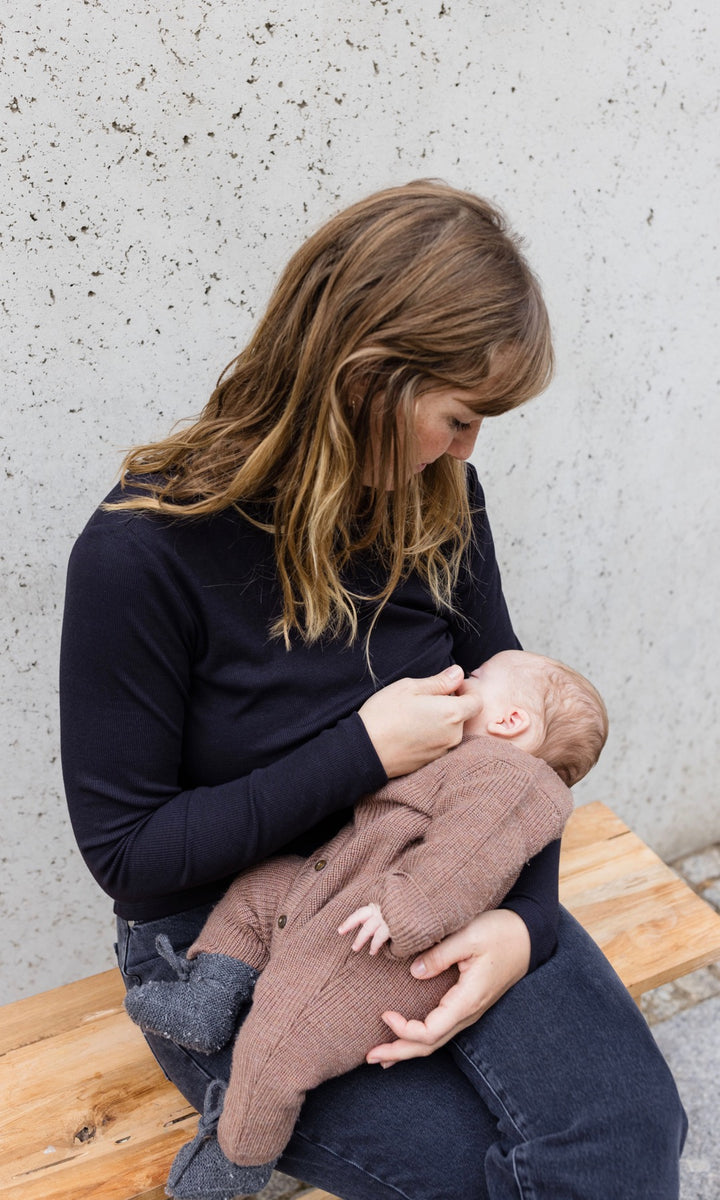 Longsleeve Stilloberteil Cléo mit Rollkragen in schwarz beim Stillen mit Stillfunktion Blick zu Baby