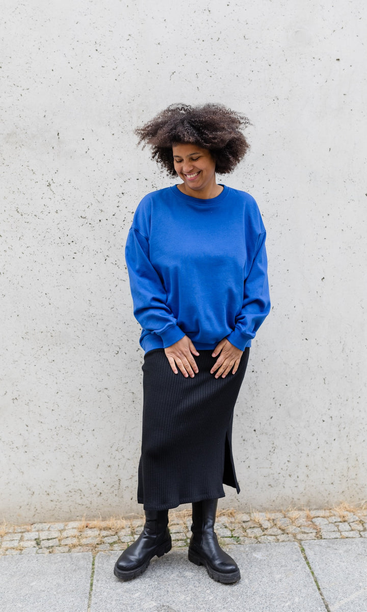 Strickrock Jil in schwarz kombiniert mit Lederstiefeln und blauem Strickpullover - Vorderansicht