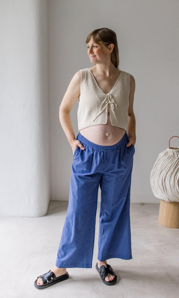 Umstandshose Ivy Culotte in blau kombiniert mit hellem Baumwoll-Strickpullunder und schwarzen Sandalen. Vorderansicht.