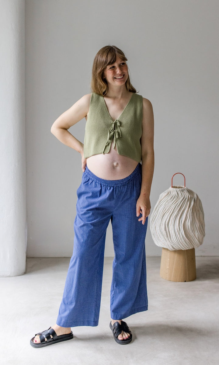 Umstandshose Ivy Culotte in blau kombiniert mit grünem Baumwoll-Strickpullunder und schwarzen Sandalen. Vorderansicht.