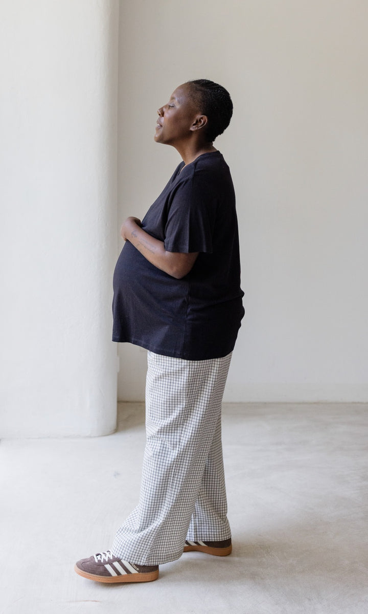 Umstandshose Ivy Culotte in karo weiß kombiniert mit dunkelblauem T-Shirt und braunen Sneakers. Seitenansicht.
