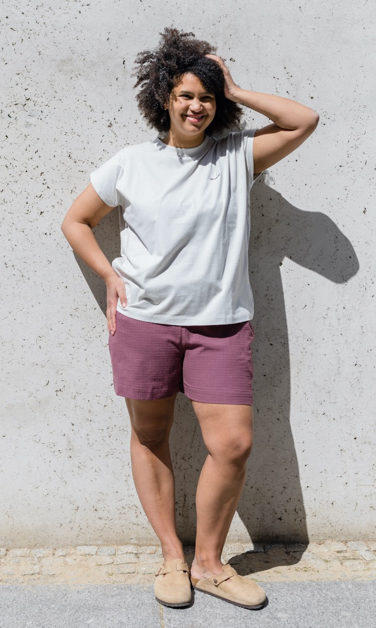 Umstands Shorts Jeanne in rot kombiniert mit hellgrauem T-Shirt mit hellbraunen Clogs