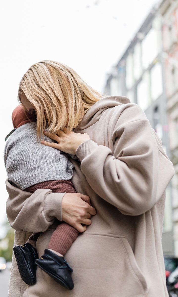 Stillhoodie in sesam weiß stehend im Winter mit Baby auf Arm